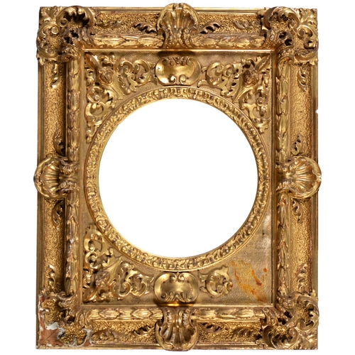 786 - A giltwood and composition picture frame, c1870, with high relief applied masks and Venus shells, si... 