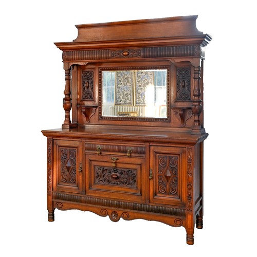 993 - An Edwardian oak sideboard, with bevelled mirror to the canopied back, substantial brass drop handle... 