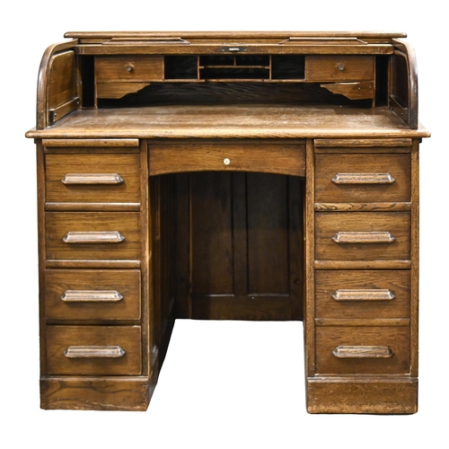 607 - An oak pedestal desk, with fitted interior and tambour shutter, bearing trade label for Dawson &... 