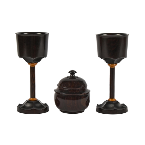 586 - A pair of turned macassar ebony goblets, 17cm h, steel insert in base stamped R. KELL 1981 and a con... 