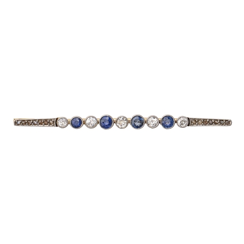 154 - A sapphire and diamond brooch, early 20th c, millegrain and collet set in gold, 60mm l, 3.6g... 