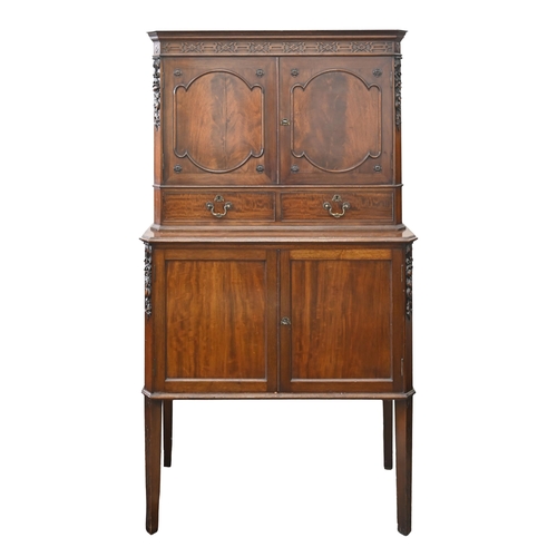 1083 - A 1930s mahogany cocktail cabinet, with carved decoration, enclosed by panelled doors, on square tap... 