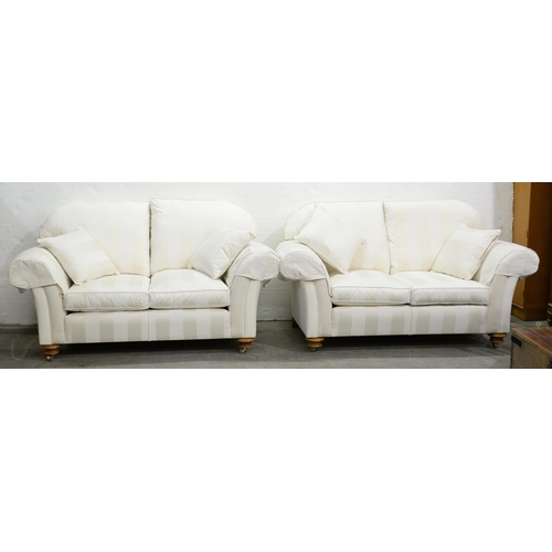 1190 - A pair of modern chesterfield sofas, in white stripe upholstery, on light wood bun feet with brass c... 