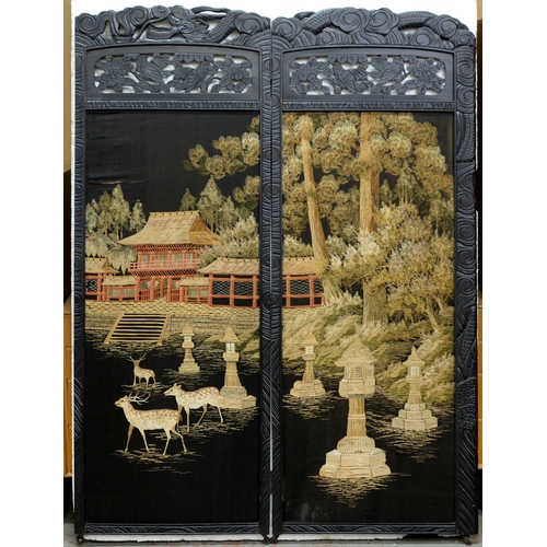 1205 - A South East Asian ebonised two leaf screen, with needlework landscape panel, the frame carved with ... 