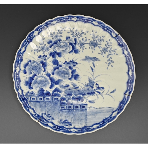 483 - A Japanese fluted blue and white dish, early 20th c, painted with bird and flowers, 47.5cm diam... 