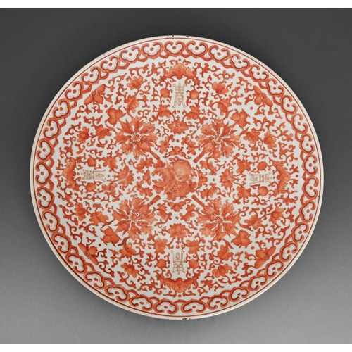 484 - A Chinese porcelain dish, late 19th c, painted in red monochrome with lotus, peaches and gilt shou c... 