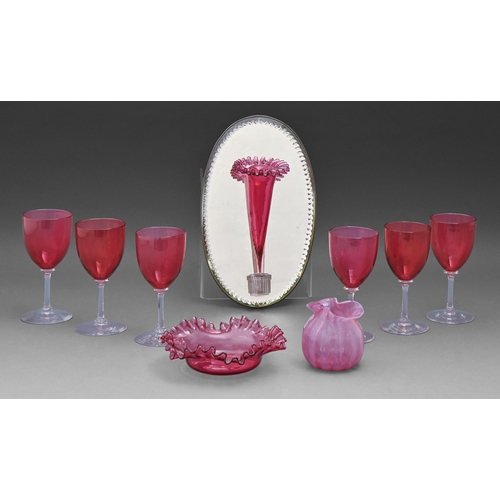 509 - A Victorian wall hanging oval mirror backed cranberry glass vase, 25cm h, a set of six cranberry gla... 