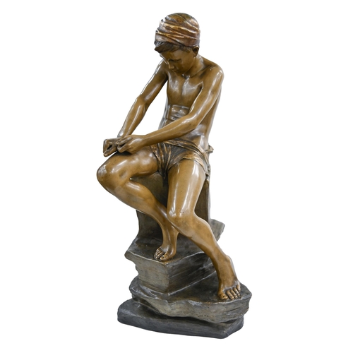 563 - A Goldscheider bronze painted and gilt terracotta figure of an archer boy whittling a stick, 1897-19... 