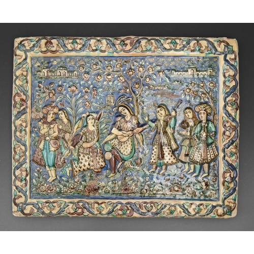 586 - A Qajar style relief moulded tile, 20th c, of a group of musicians and other figures before a blosso... 