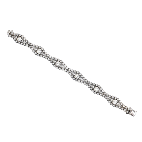 99 - A diamond bracelet, designed as a swelling, wavy ribbon with larger round brilliant cut diamonds at ... 