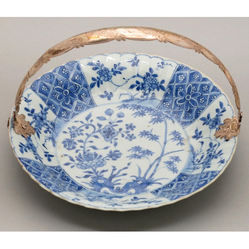 123 - A Chinese blue and white dish, Kangxi period, painted with peony and bamboo sprouting from hollow ro... 