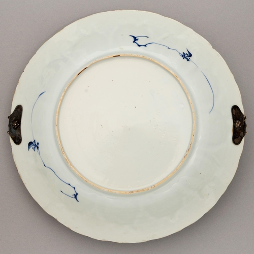 124 - A Chinese blue and white dish, Kangxi period, painted with two figures by a house and hollow rocks, ... 