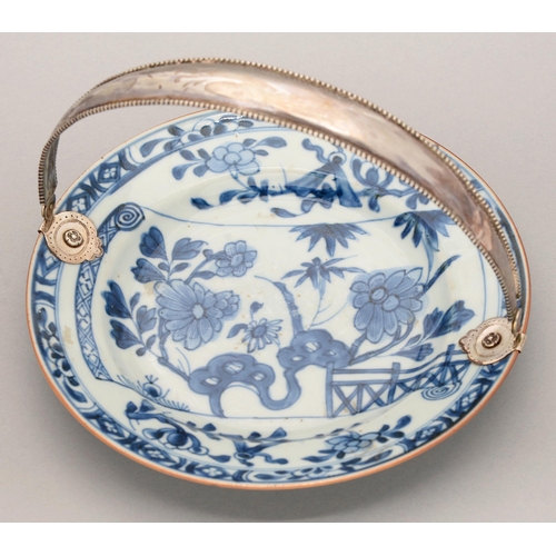 125 - A Chinese blue and white plate, 18th c, painted with a flowering plant, bamboo and fence on a scroll... 