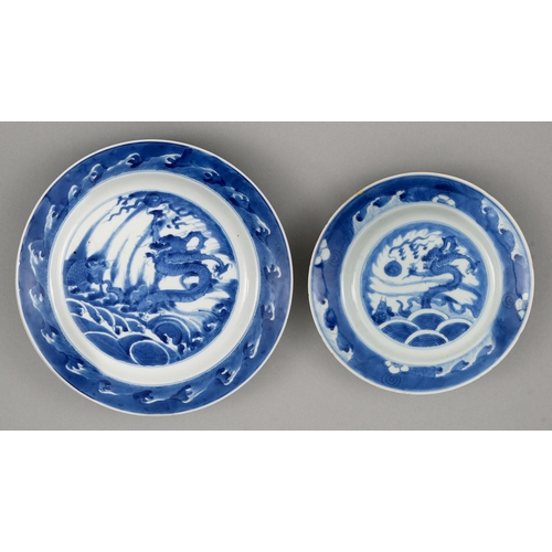 129 - Two graduated Chinese blue and white plates, 18th c, painted with dragon and carp rising from surgin... 