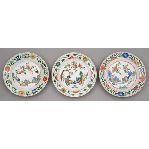 149 - Three Chinese famille verte plates, Kangxi period, enamelled with two dogs of Fo beneath a flowering... 