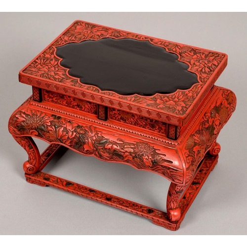 180 - A Chinese cinnabar lacquer stand, 19th / early 20th c, the unadorned glossy black shaped centre of t... 