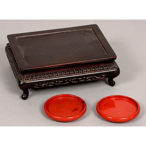 181 - A pair of Chinese plain round cinnabar lacquer stands, 20th c, 87mm diam and a Chinese hardwood low ... 