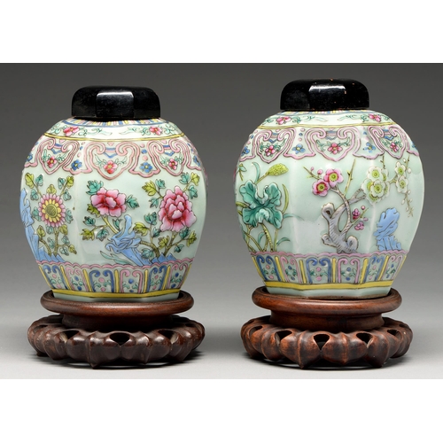 215 - A pair of Chinese celadon ground famille rose moulded octagonal jars, 20th c, decorated with lotus, ... 