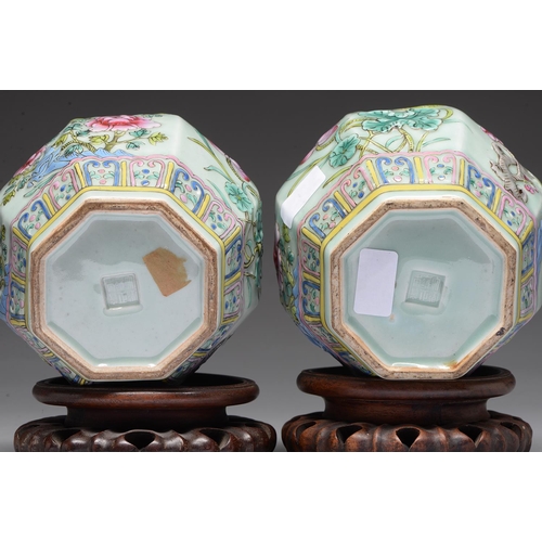 215 - A pair of Chinese celadon ground famille rose moulded octagonal jars, 20th c, decorated with lotus, ... 