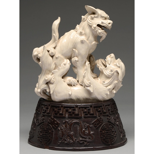 231 - A Chinese glazed porcelain group of fighting lion dogs, 19th c or later, 28cm h, wood stand carved w... 