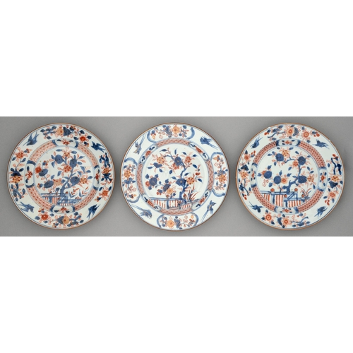 245 - Three Chinese Imari plates, 18th c, painted with a blossoming tree and fence in panelled diaper cave... 