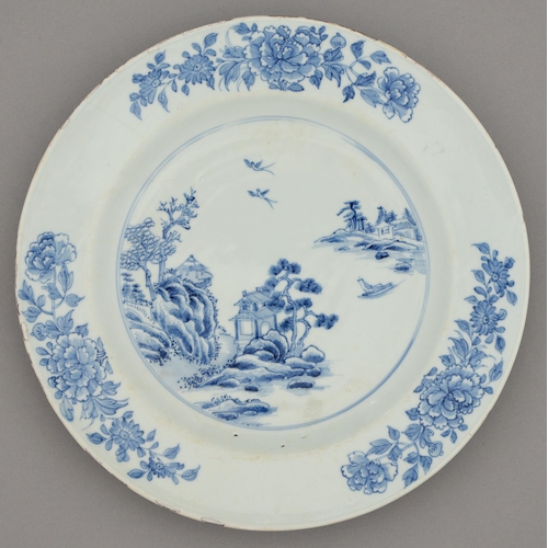 258 - A Chinese blue and white dish, 18th c, painted with a river scene and three trailing peony sprays, 3... 