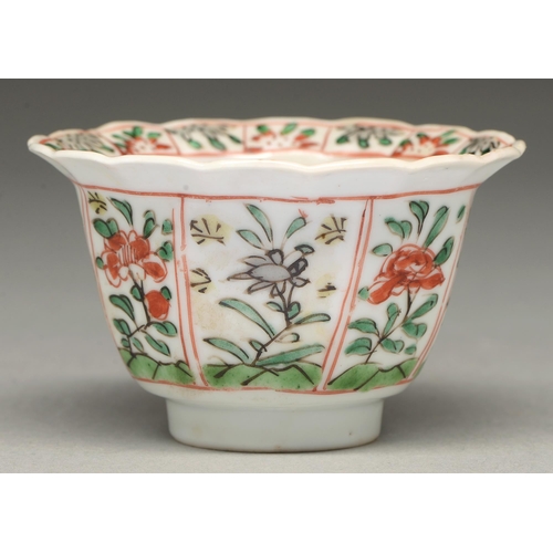 314 - A Chinese famille verte tea bowl, Kangxi period, painted with flower panels to the exterior and lobe... 