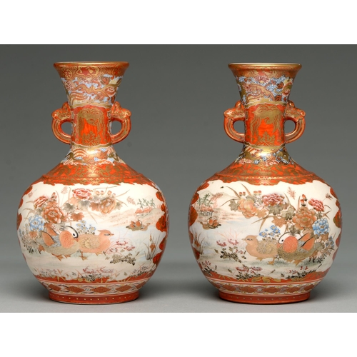 375 - A pair of Kutani ware vases, early 20th c, the flared neck with mask handles and painted with panels... 