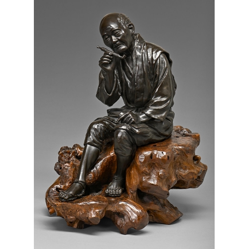 405 - A Japanese bronze sculpture of a man, seated with contemplative expression holding his tobacco pipe ... 