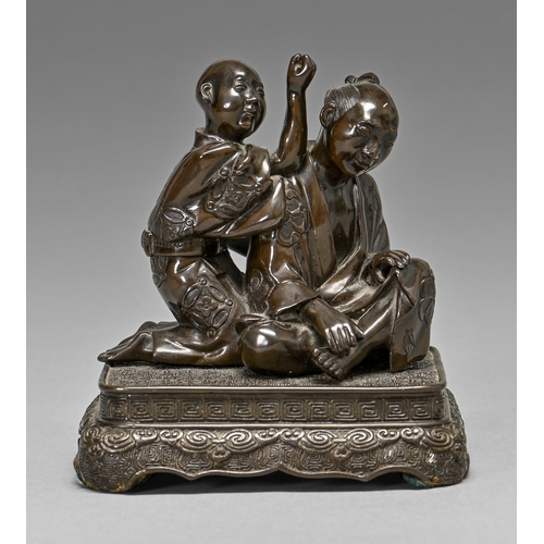 438 - A Japanese bronze group, Meiji period, of a seated man and boy kneeling at his shoulder, mounted on ... 