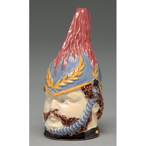 577 - An enamelled creamware candle snuffer in the form of the head of a soldier, 19th c, 95mm h... 