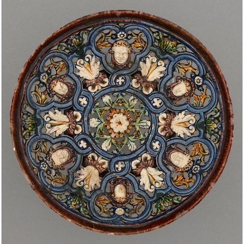 610 - A Palissy ware  ajoure dish, 19th c moulded with grotesque masks and foliage in a pattern of strapwo... 