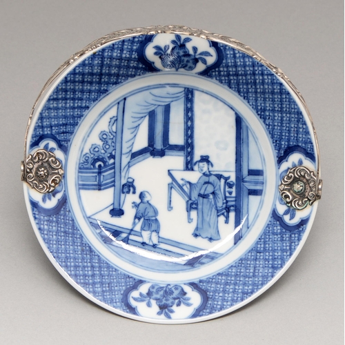 94 - A Chinese blue and white plate, Kangxi period, painted with a lady addressing a house boy, the diape... 