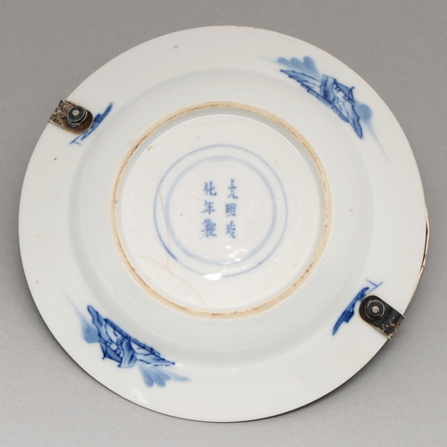 94 - A Chinese blue and white plate, Kangxi period, painted with a lady addressing a house boy, the diape... 