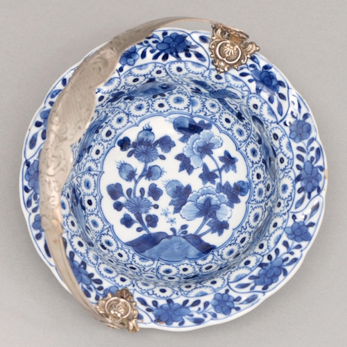 95 - A Chinese blue and white dish, 18th c, painted to the well with two flowering plants in lotus shaped... 