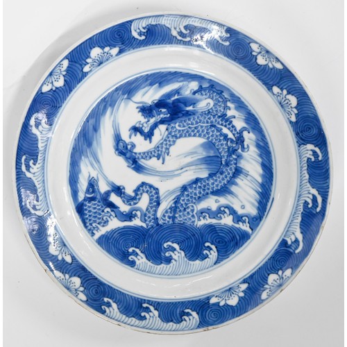 121 - A pair of Chinese blue and white plates, Kangxi period, painted with dragon and carp in wave border,... 