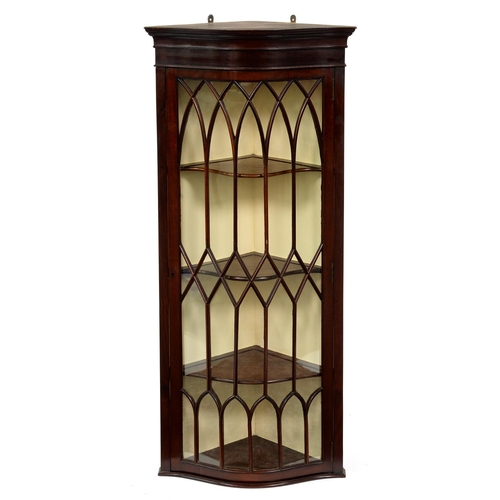 1225 - An Edwardian serpentine mahogany hanging corner cabinet, the glazed door with lancet and diamond gla... 