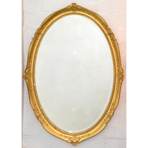 1135 - A giltwood and composition oval mirror, early 20th c, with bevelled plate, 89cm h