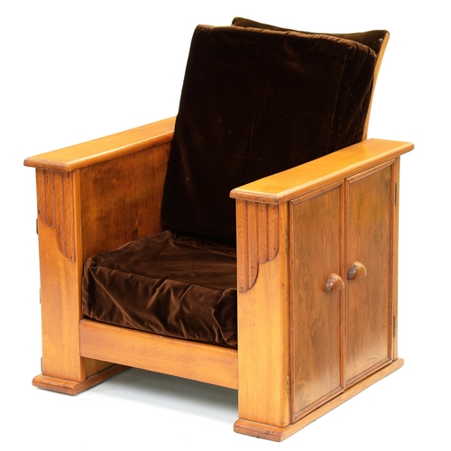 1188 - An Art Deco varnished light wood armchair,  the sides with shelves, on one enclosed by two doors, 79... 