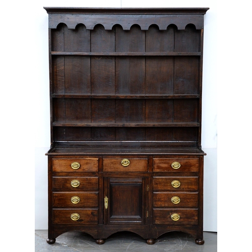 1216 - A stained oak dresser, 20th c,  with boarded rack, the base with panelled sides, 208cm h; 41 x 140cm... 