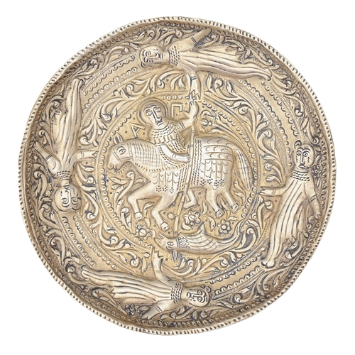 366 - A South East European repousse silver coloured metal dish, possibly 19th c, with St. George slaying ... 