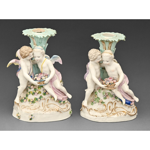 388 - A pair of Volkstedt candelabra groups of two putti, with a basket of flowers, early 20th c 22cm h... 