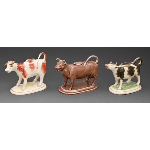 425 - A Victorian earthenware cow creamer and cover,  with manganese glaze with silver lustre horns and ta... 