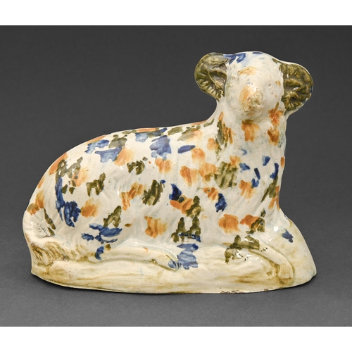 450 - An English pearlware model of a recumbent sheep, early 19th c, decorated in underglaze enamels in th... 