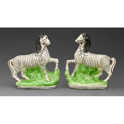 454 - Two Staffordshire earthenware flatback models of zebra, second half 19th c, on vivid green base, 21c... 