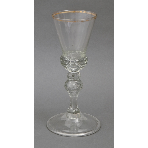 473 - A German wine glass, mid 18th c,  the conical bowl with gilt rim and faceted base, on inverted balus... 