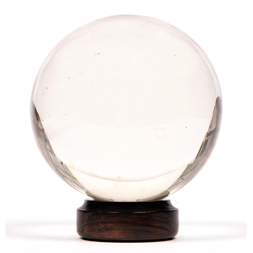 786 - Divination. A crystal ball, early 20th c, of rock crystal, 14cm h, wood stand (2)