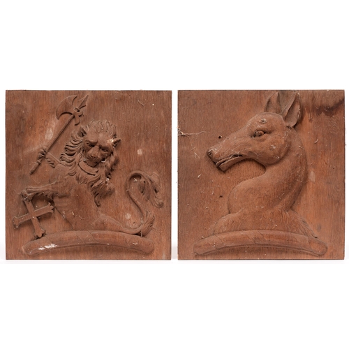 849 - A pair of heraldic carved oak plaques, early 20th c, one with a lion crest the other with a head of ... 