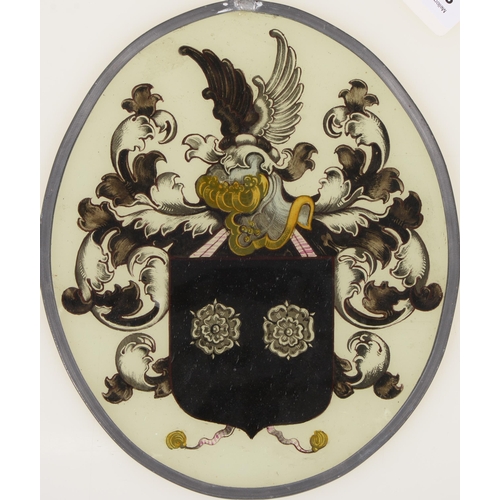 885 - A Northern European stained glass armorial window light, 19th c, with crest, shield, helm and leafy ... 