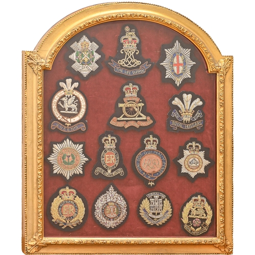 943 - Militaria. A framed group of fourteen British regimental cloth and metal thread badges, including Gu... 